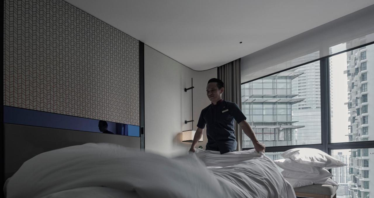Amari Kuala Lumpur Hotel Buitenkant foto A hotel housekeeper making a bed